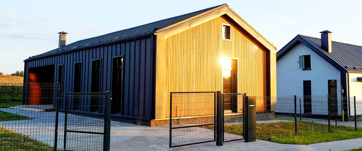 Barndominium completed with vertical metal siding and fenced yard